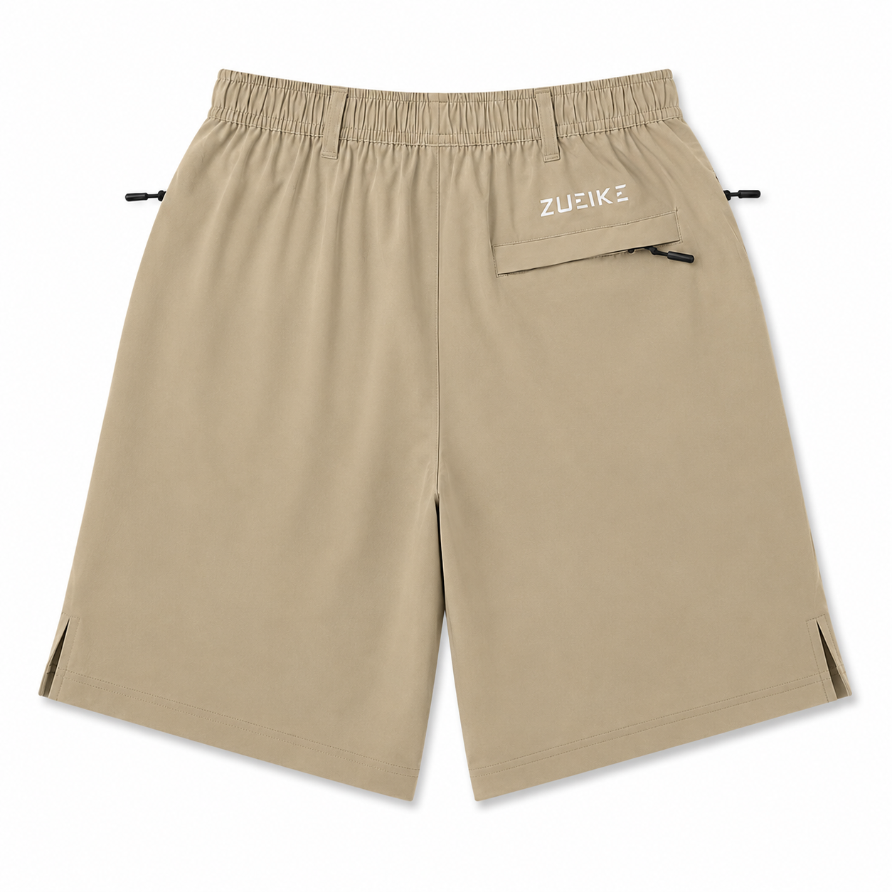 A pair of beige athletic shorts with an elastic waistband, side slits, and a small zippered pocket on the left hip featuring the white 'ZUZIKZ' brand logo, shown against a plain white background.